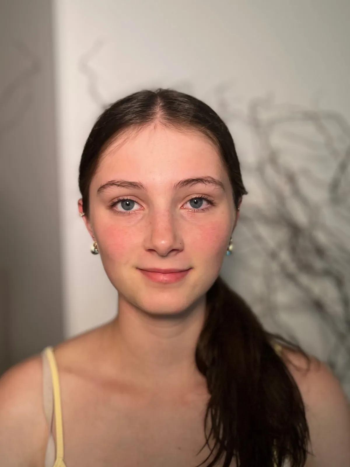 Junge Frau mit dunklen Haaren ungeschminkt, vor dem Make-up